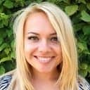 Lächelnde blonde Frau vor grünem Hintergrund