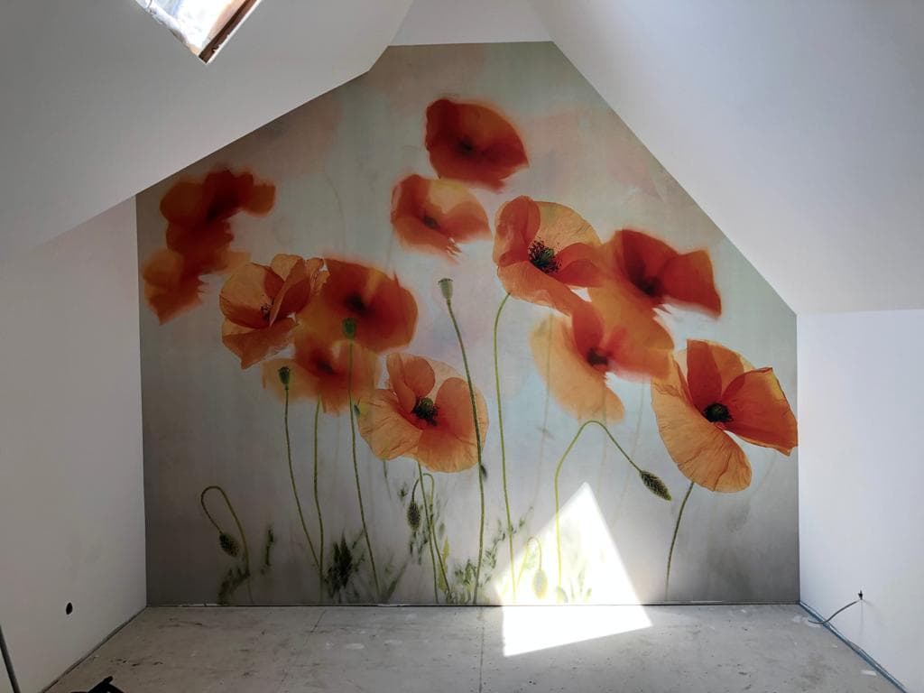 Dachgeschossraum mit großflächiger Wandgestaltung aus orangefarbenen Mohnblumen